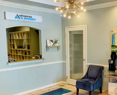 advances in dentistry reception area with front desk window and blue comfy chair
