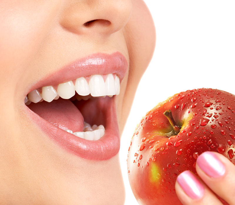 Woman about to bite into a red apple